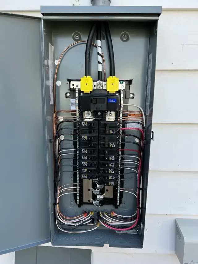 An open residential electrical panel with neatly dressed wiring