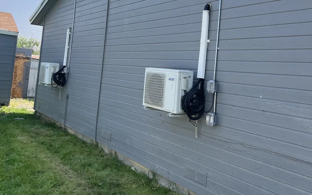 Mini-split condensers on grey siding, each with its own disconnect and a straight conduit run
