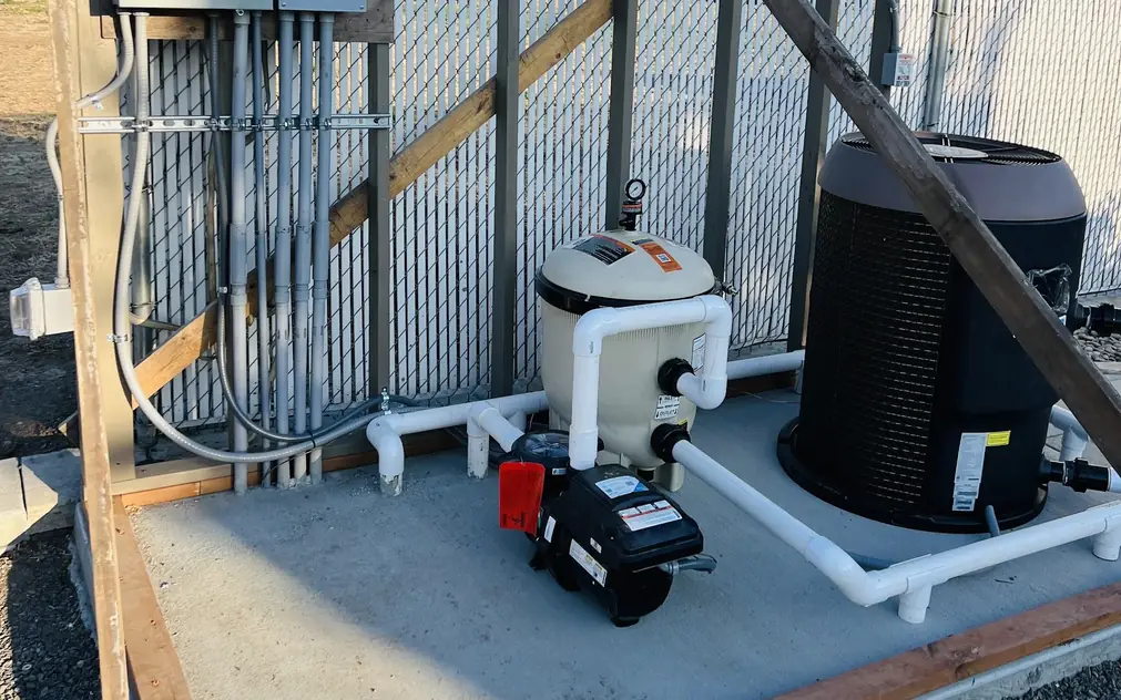 Pool pump, filter and heat pump fed by a bank of disconnects and straight conduit runs on a new pad